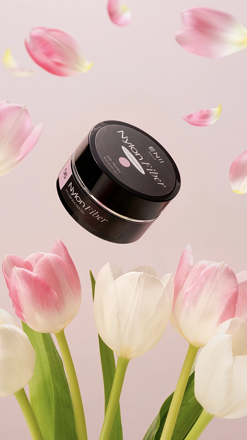 Gel na nehty levitující nad tulipány na pudrově růžovém pozadí